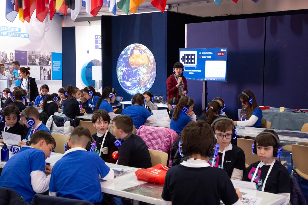 Kids with headphones at ESRIN digital lab with Earth globe